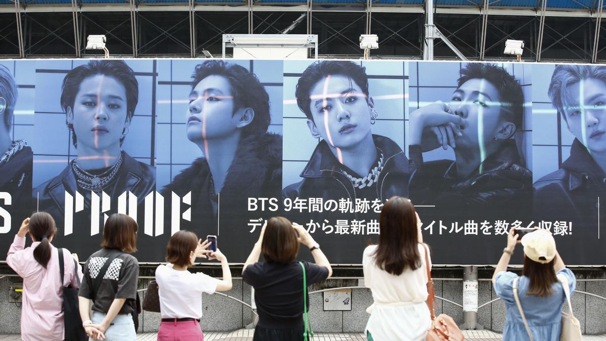 June 10, 2022, Tokyo Japan: People take photos of a giant billboard of the South Korean boy band BTS (Bangtan Boys) announcing their new album Proof outside Shibuya Station. Their album Proof and its title track Yet To Come were released on June 10. (Cred