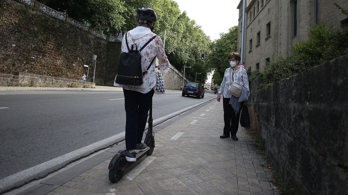 Una mujer en patinete y otra caminando por la cuesta de Labrit.