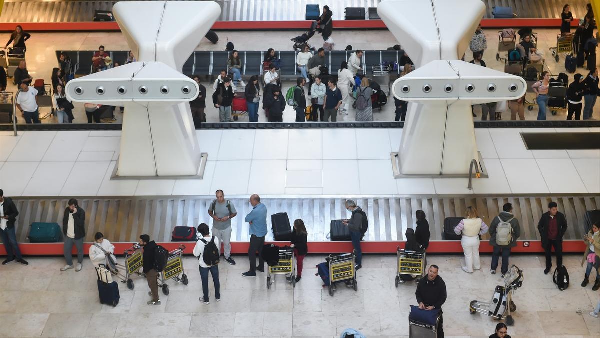 Pasajeros recogen sus maletas durante el último día de la huelga del servicio de handling de Iberia.