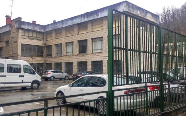 Vista del exterior del edificio que albergó las antiguas escuelas de Pedro Muguruza y va a ser demolido para generar espacio para aparcamiento y una plaza abierta al río Deba.
