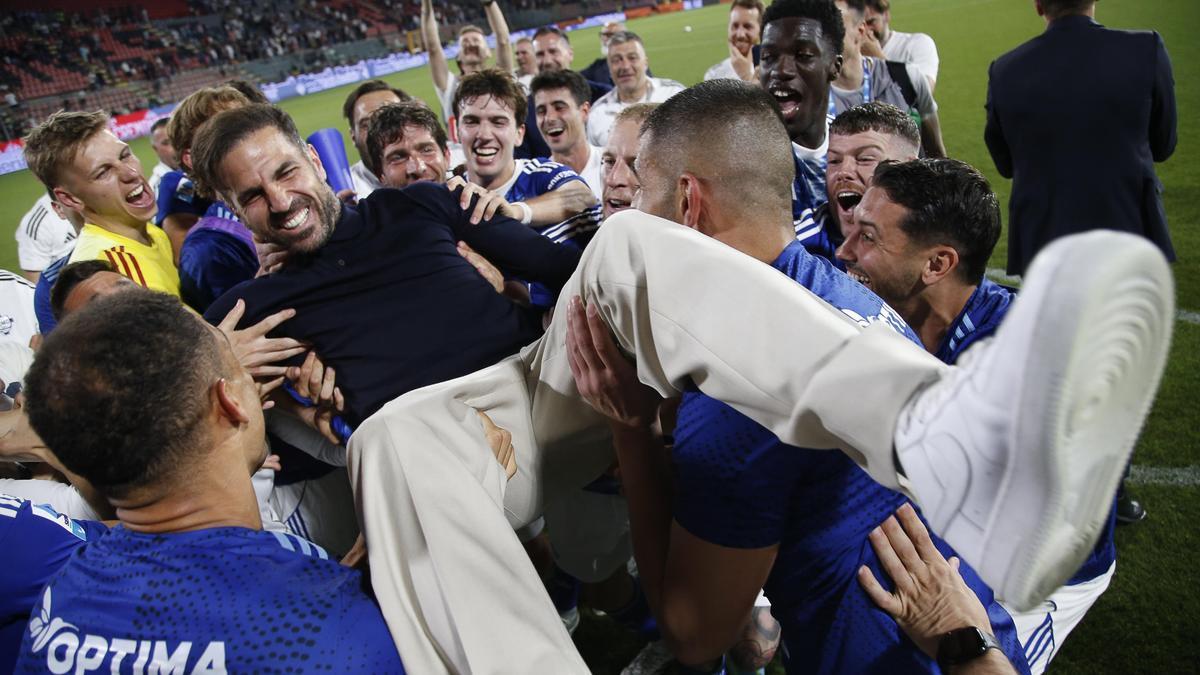 Los jugadores del Como mantean a Cesc Fábregas, el técnico que les ha guiado a la primera participación del club en la Champions League.
