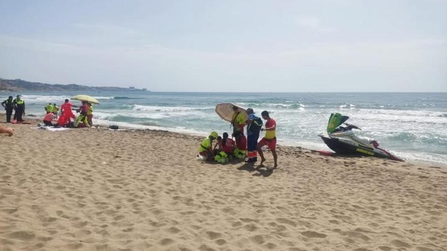 Socorristas atendiendo a dos personas con signos de ahogamiento en una playa de Fuengirola.