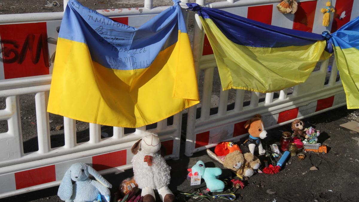 Banderas ucranianas, muñecos de peluche y dibujos en recuerdo a los fallecidos en la ciudad de Dnipro.