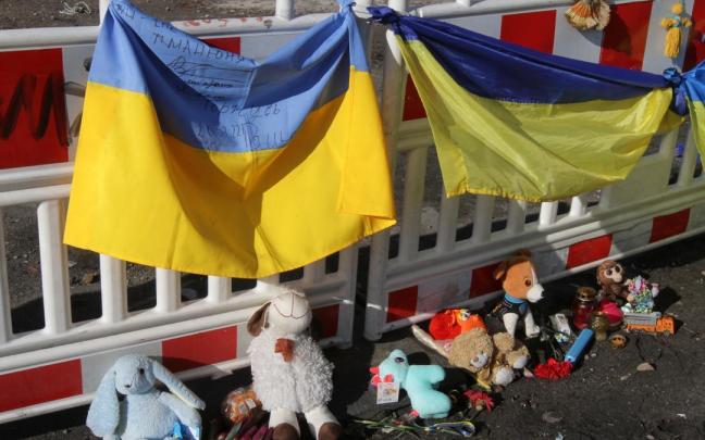 Banderas ucranianas, muñecos de peluche y dibujos en recuerdo a los fallecidos en la ciudad de Dnipro.