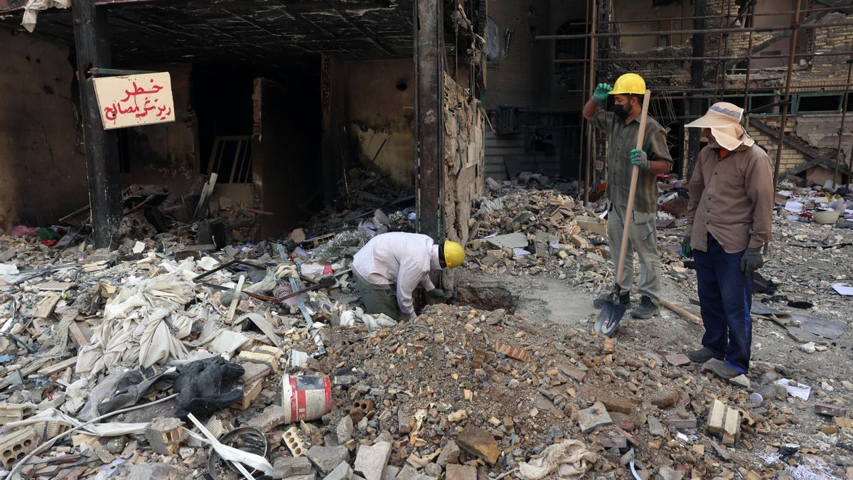 Iraníes trabajan en los edificios residenciales destruidos por los ataques aéreos estadounidenses e israelíes al sur de Teherán.