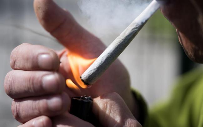 Fumador encendiéndose un cigarro.