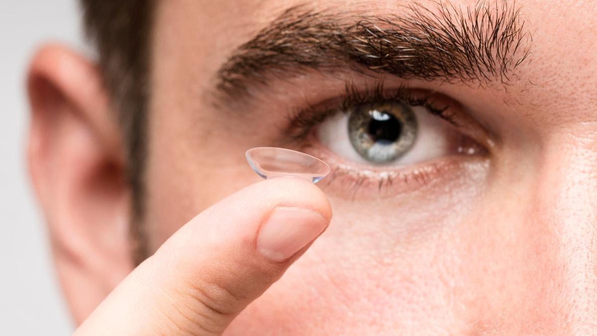 Un hombre a punto de colocarse una lentilla en el ojo.