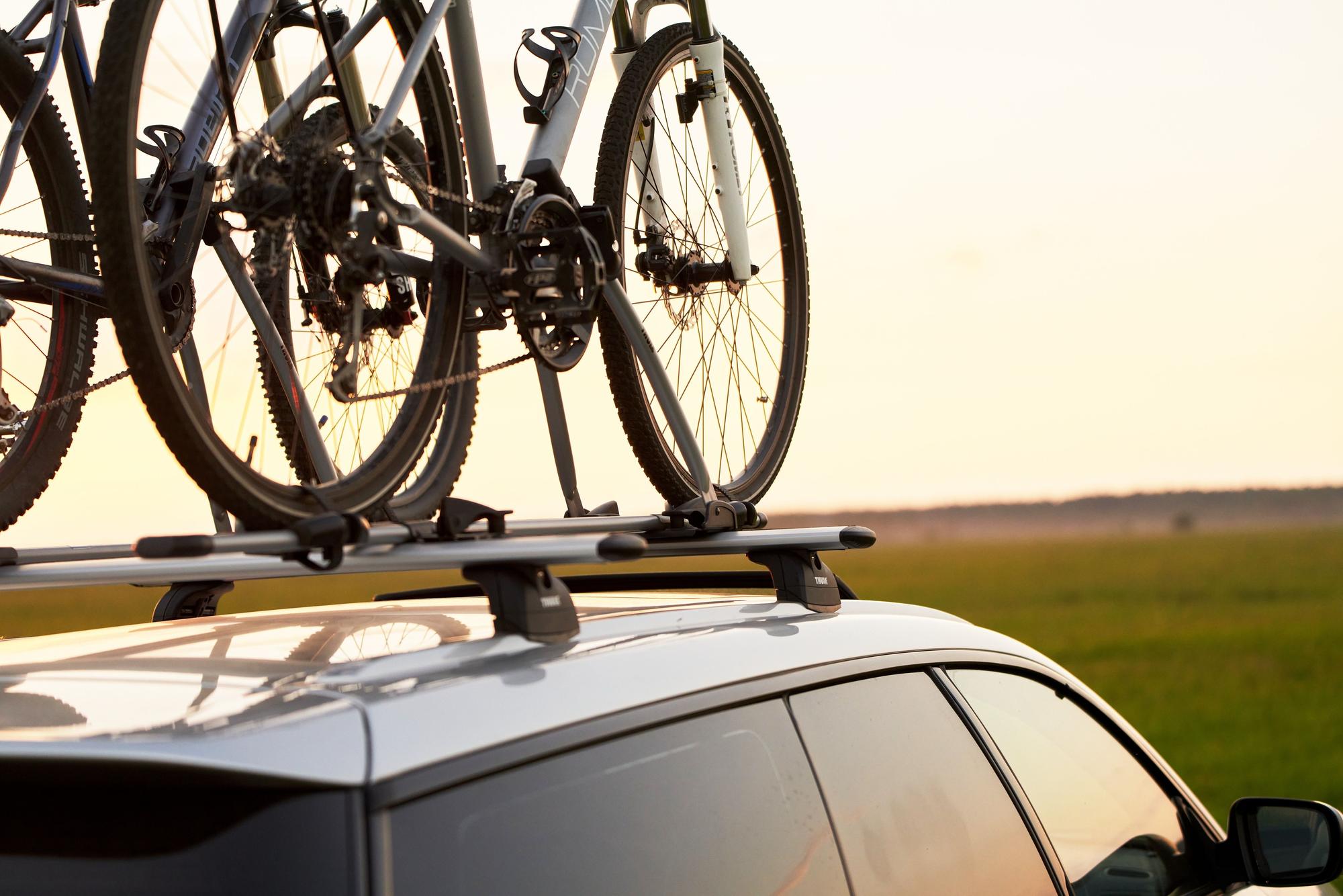 Unas bicis colocadas sobre el techo de un coche.