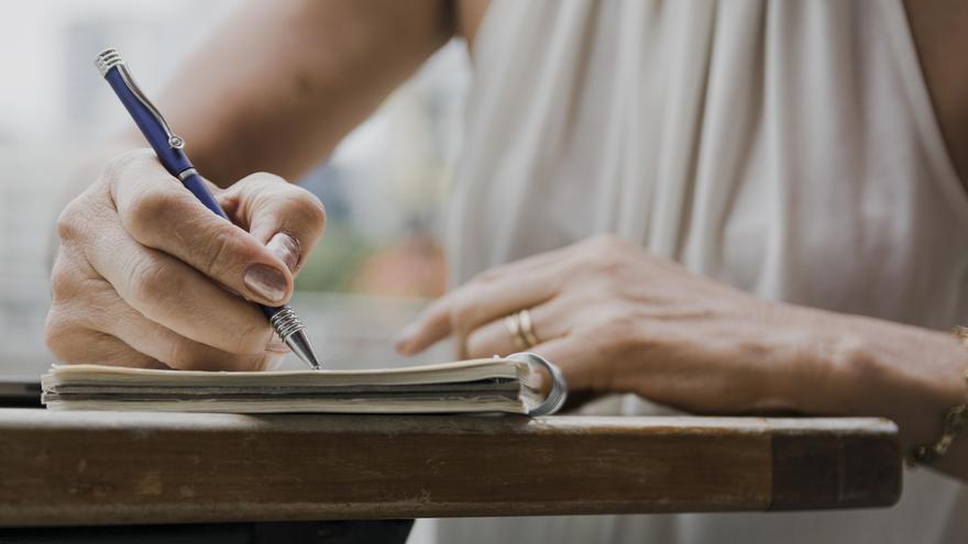 Una persona escribe a mano en un cuaderno.