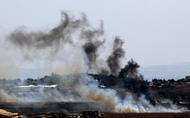 Un denso humo se eleva debido a los bombardeos israelíes en campos abiertos en la aldea de Marjayounm, en la frontera sur del Líbano, donde se ve a la derecha el asentamiento israelí de Metulla, en el norte de Israel.