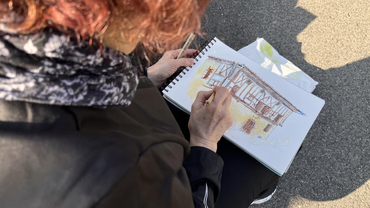 Una mujer dibujando el Palacio de Igartza de Beasain.