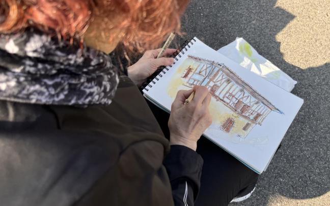 Una mujer dibujando el Palacio de Igartza de Beasain.