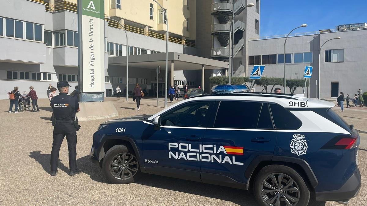 Un agente de la Policía Nacional junto a su vehículo en Málaga.