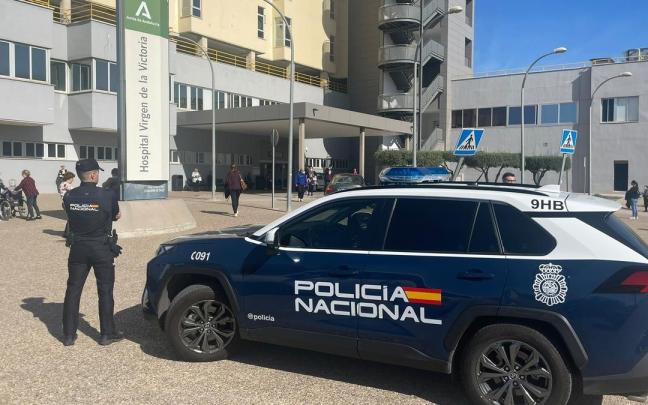 Un agente de la Policía Nacional junto a su vehículo en Málaga.