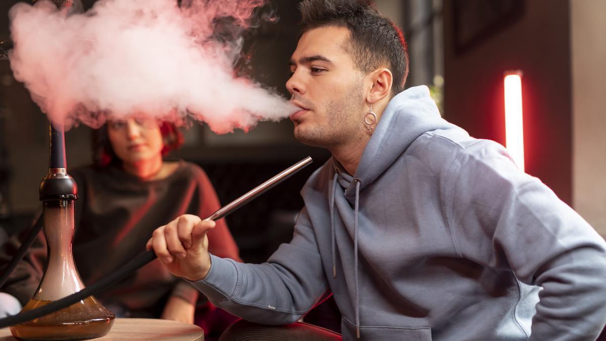 Un joven fumando shisha.