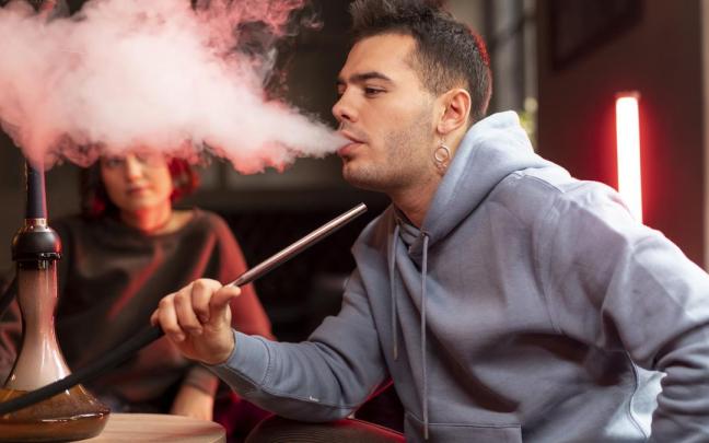 Un joven fumando shisha.