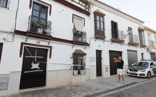 Un hombre fotografía la vivienda de Osuna en la que se encontraron los cadáveres. Un hombre fotografía la vivienda de Osuna en la que se encontraron los cadáveres.