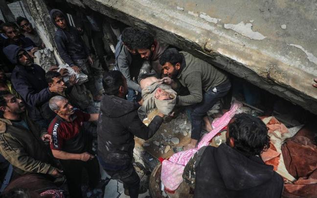 Varis personas rescatan de entre los escombros a víctimas de bombardeos israelíes.