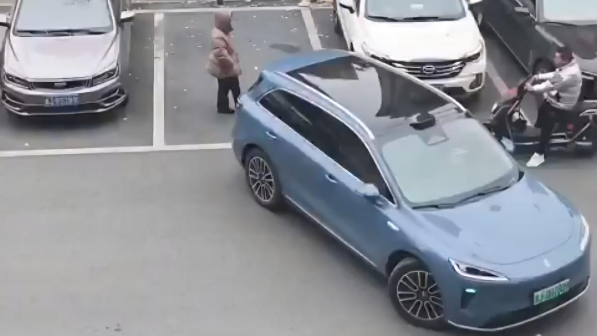 La mujer que guarda el sitio y el coche que intenta aparcar.