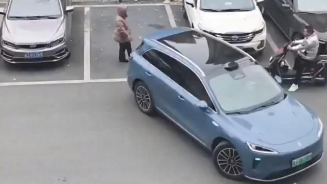 La mujer que guarda el sitio y el coche que intenta aparcar.