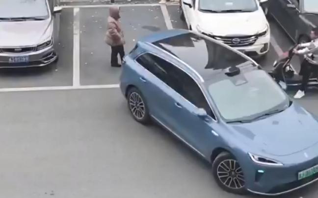 La mujer que guarda el sitio y el coche que intenta aparcar.