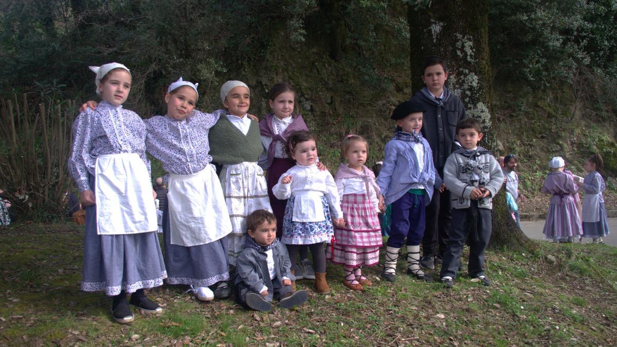 Los niños y niñas de Eleizondo, junto a la encina de la Piedad y muy atentos a los actos tradicionales