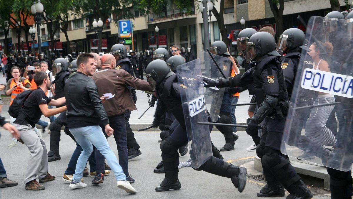 Agentes de la policía nacional intentan retirar a los concentrados ante los colegios electorales el 1 de octubre de 2017.