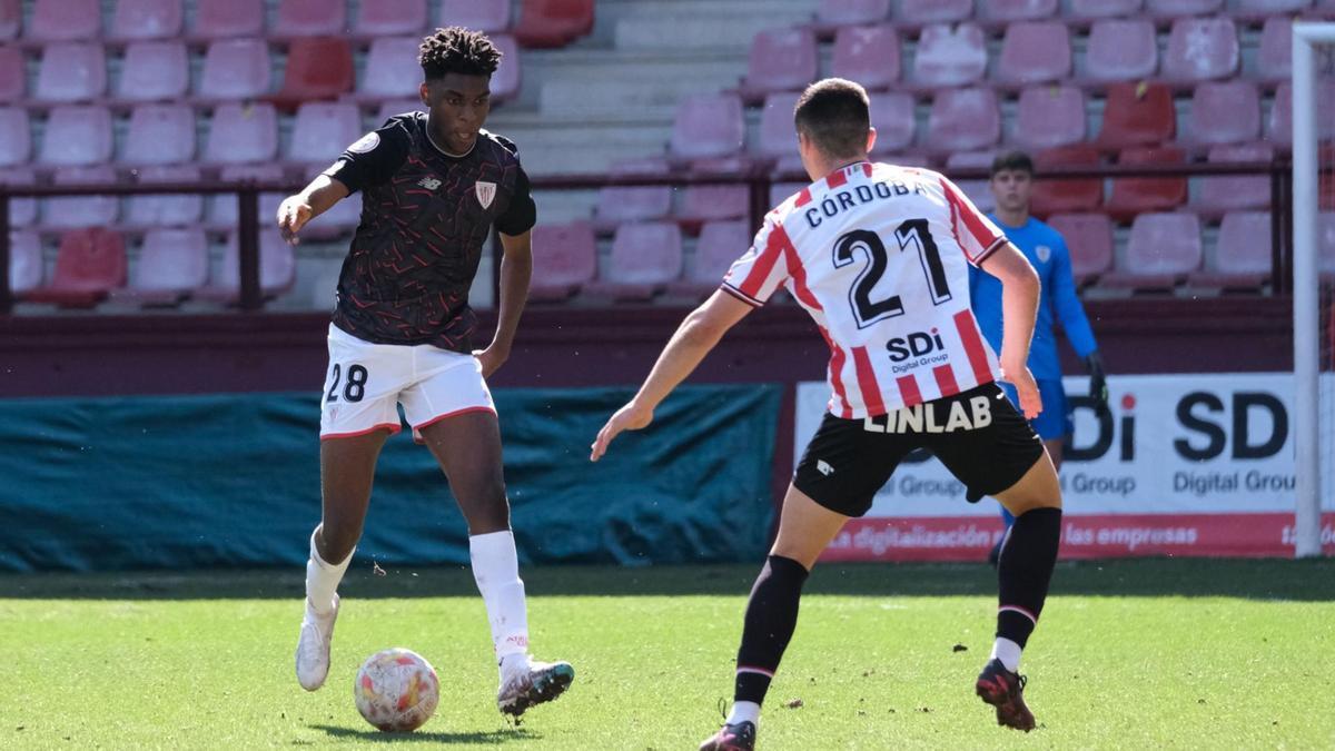 Wibuala Junior Bita, que debutó en Las Gaunas en el Bilbao Athletic, conduce el balón ante Asier Córdoba, excachorro.