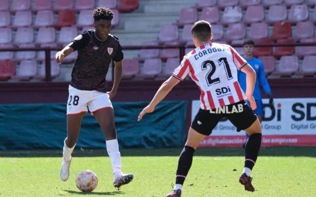 Wibuala Junior Bita, que debutó en Las Gaunas en el Bilbao Athletic, conduce el balón ante Asier Córdoba, excachorro.