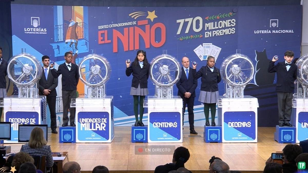 Una persona revisa varios décimos de la Lotería del Niño