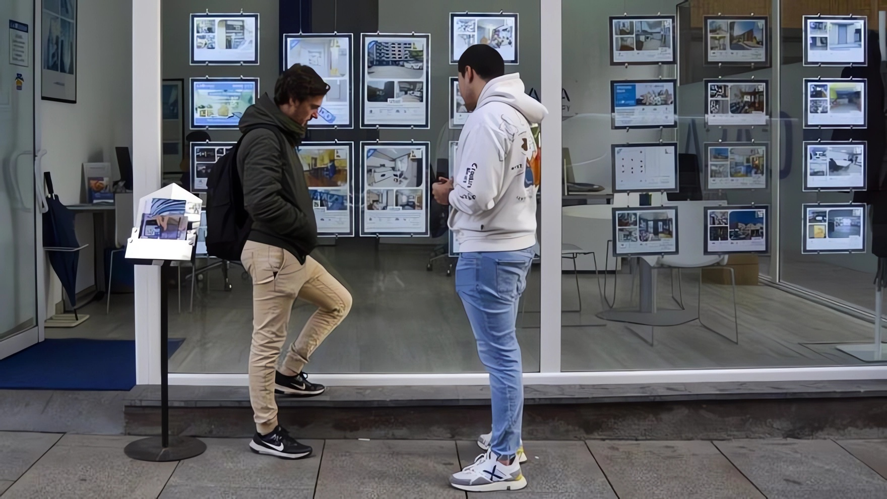 Dos jóvenes con dificultades para acceder a una vivienda frente al escaparate de una inmobiliaria / Maider Goikoetxea