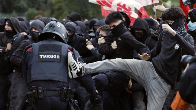 Un joven da una patada a un agente durante las protestas por la presencia de Vito Quiles en la UAB.