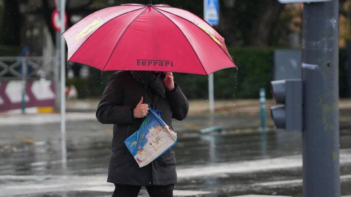 Un peatón se protege de la lluvia bajo su paragua, durante el paso de la borrasca Joseph.