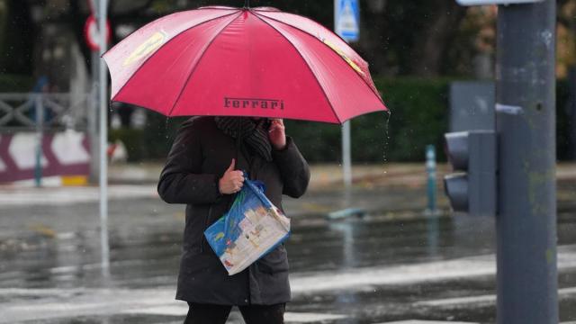 Un peatón se protege de la lluvia bajo su paragua, durante el paso de la borrasca Joseph.