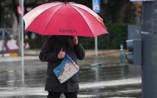 Un peatón se protege de la lluvia bajo su paragua, durante el paso de la borrasca Joseph.