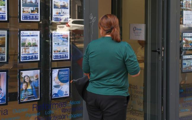 Una mujer pasea junto a una inmobiliaria. / Marta Fernández / Europa Press Una mujer pasea junto a una inmobiliaria.