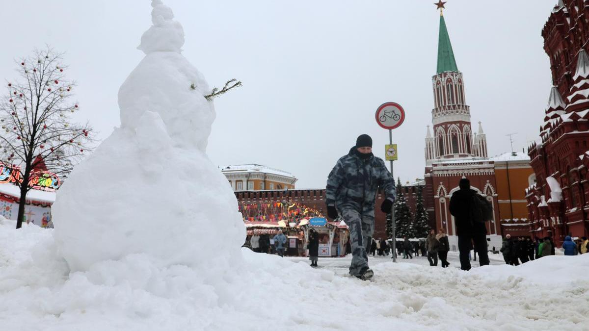 Un policía ruso camina ante un muñeco de nieve en la Plaza Roja de Moscú.