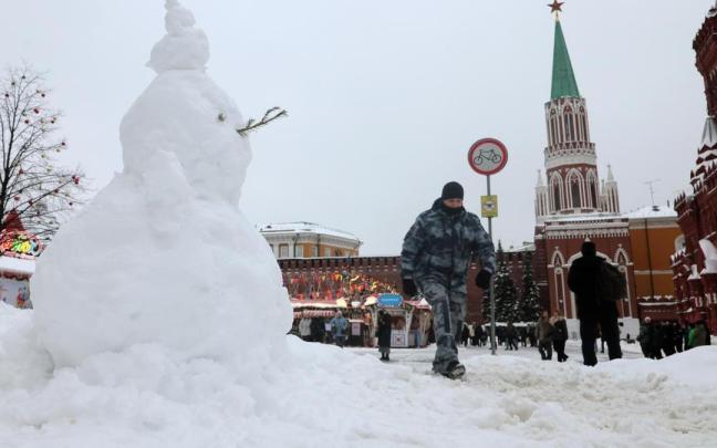 Un policía ruso camina ante un muñeco de nieve en la Plaza Roja de Moscú.