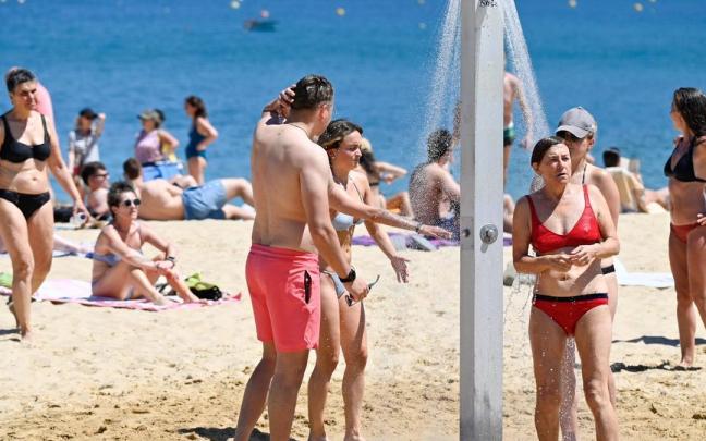 Gente refrescándose en la playa de La Concha