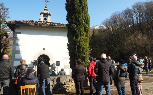 Los fieles siguente la celebración de la misa desde el exterior de la ermita del Ángel de la Guarda