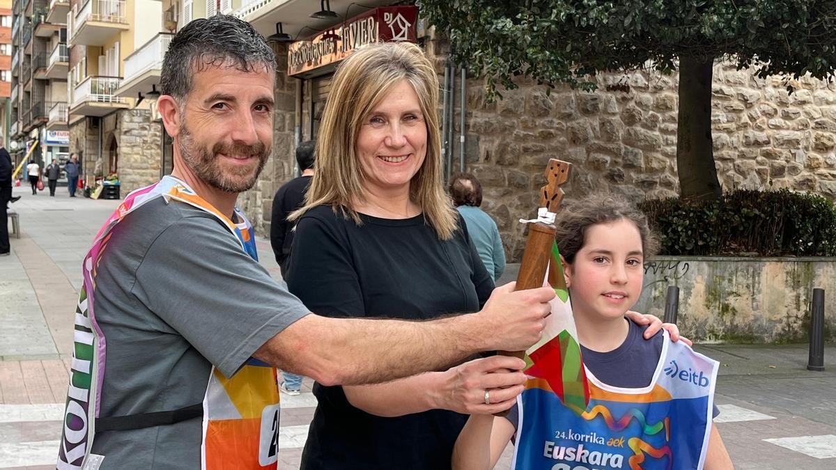 Ion Barbadillo y Julene Zubiete recibiendo el testigo y los petos de manos de la concejala de Euskera