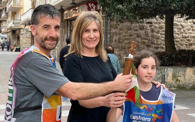 Ion Barbadillo y Julene Zubiete recibiendo el testigo y los petos de manos de la concejala de Euskera