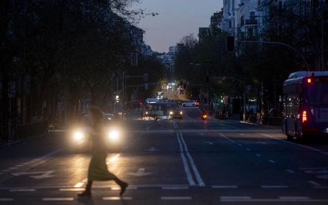 Una mujer cruza por un paso de cebra con la calle completamente oscura debido al apagón.