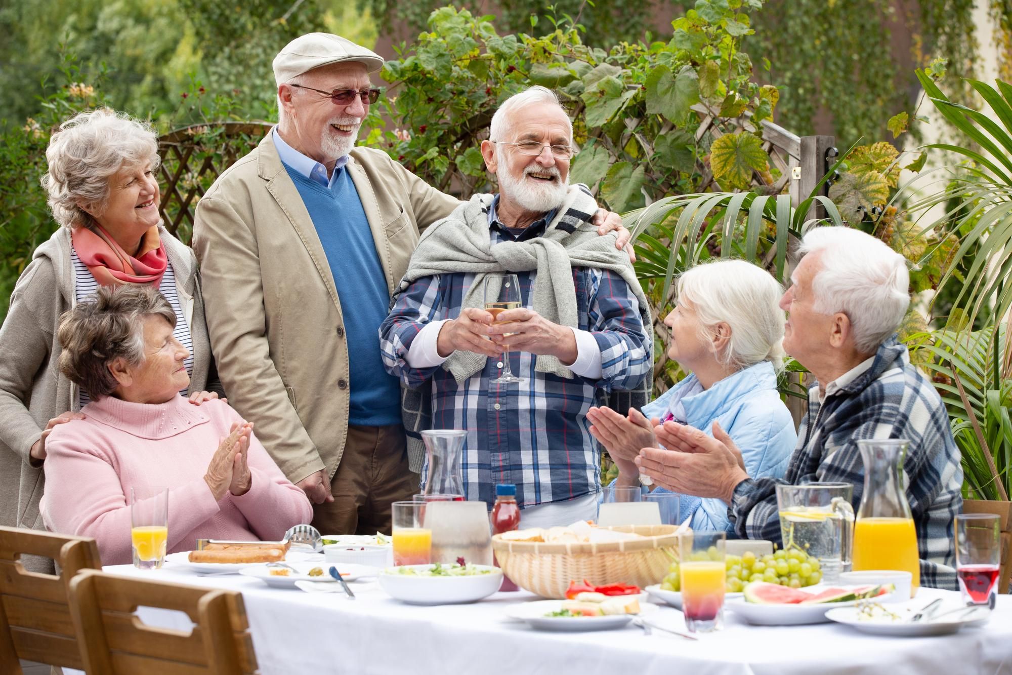 Un grupo de jubilados comparte una agradable comida al aire libre.