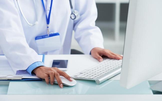 Una doctora tramita en el ordenador una incidencia de una paciente.