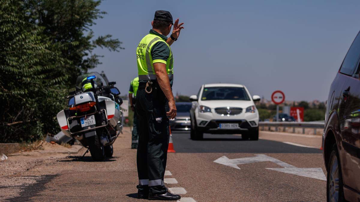 Un agente de la Guardia Civil para a un vehículo durante un control en la autovía A-5
