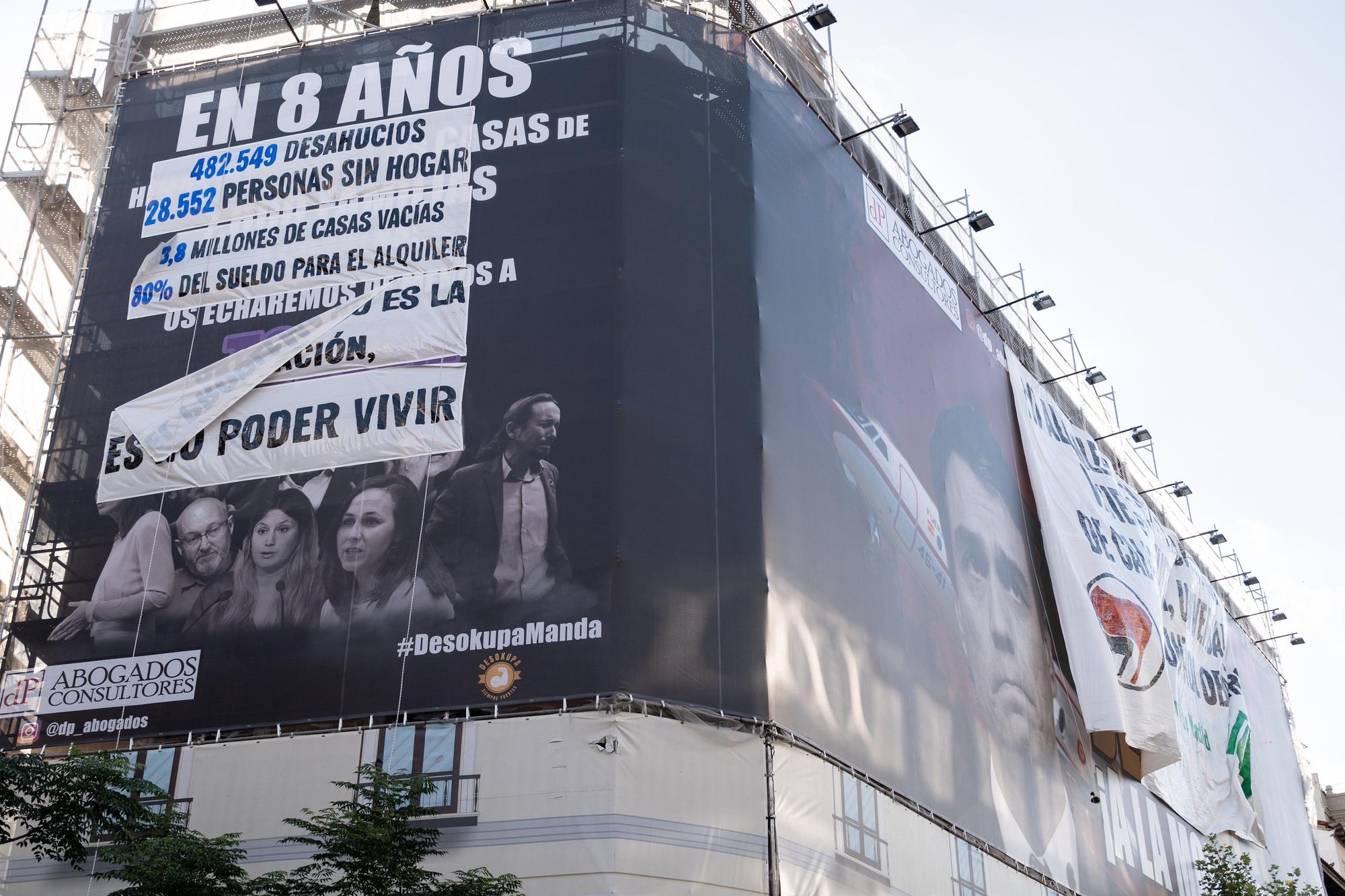 La lona desplegada por activistas antidesahucios por encima de la de Desokupa.