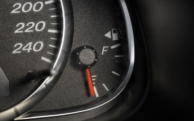 Triángulo junto al indicador del nivel de combustible en el cuadro de mandos de un coche.