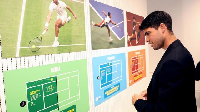 Carlos Alcaraz observa una exposición sobre su propia historia en el tenis.
