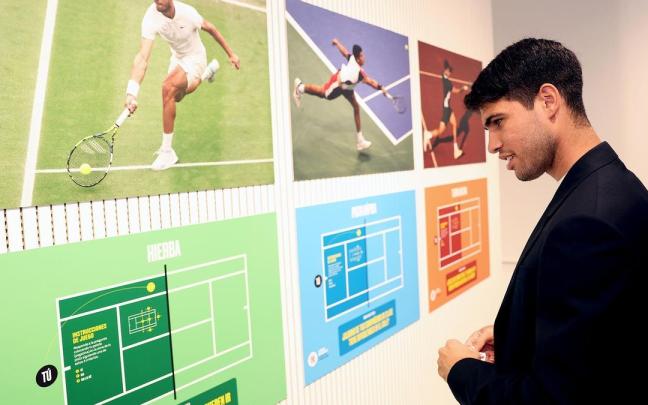 Carlos Alcaraz observa una exposición sobre su propia historia en el tenis.